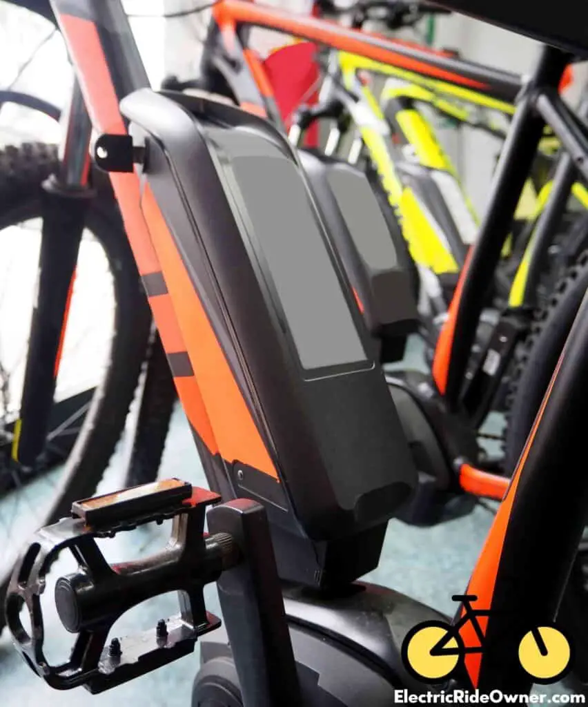 Close up on ebike battery on orange ebike in a bike shop