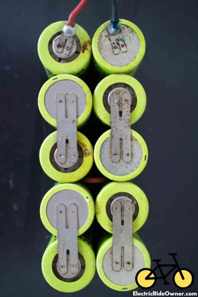 battery pack of 12 green batteries photo displays the tops of them with black wire on top right battery and red wire on top left battery