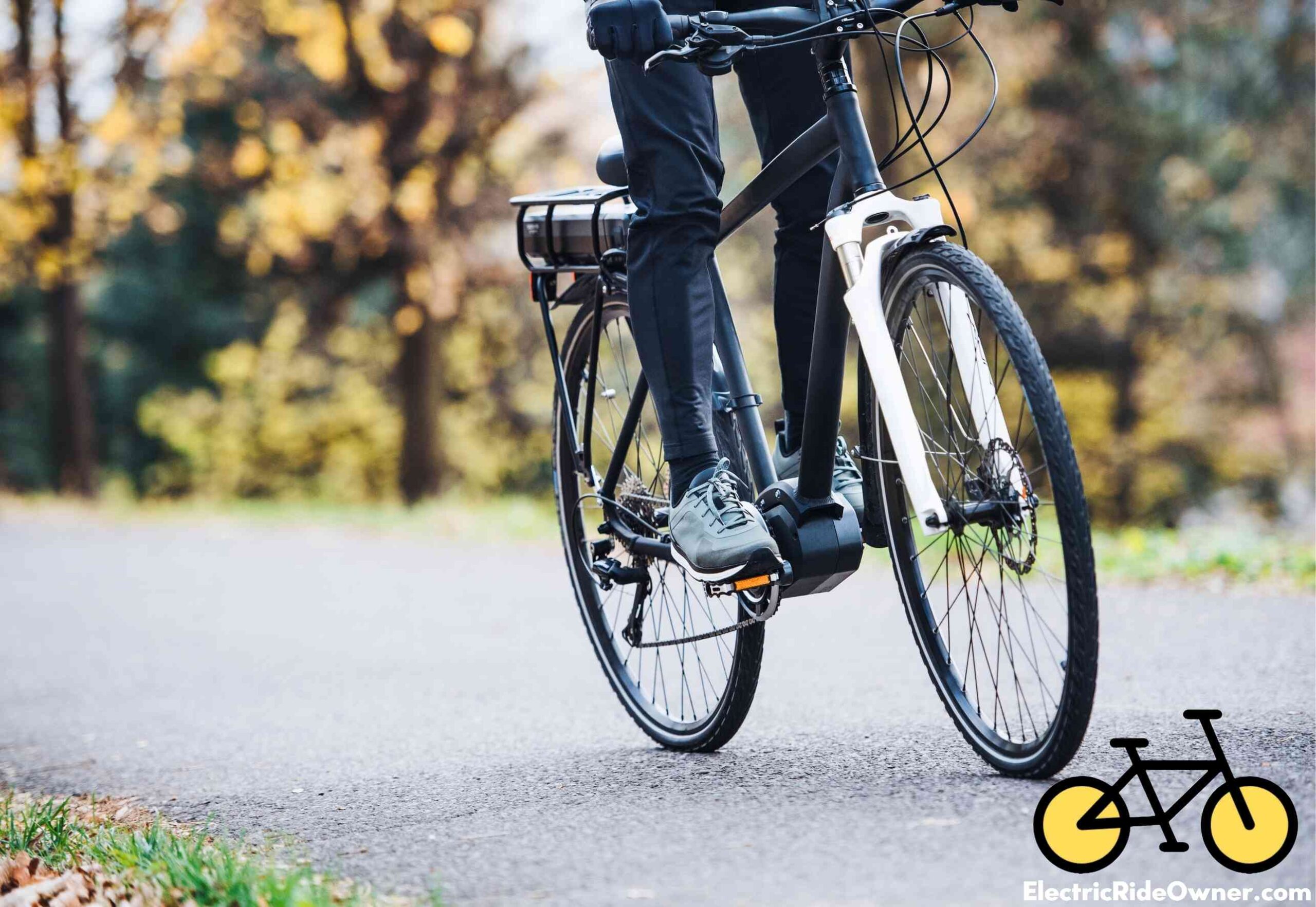 person riding an ebike on cement with trees in background