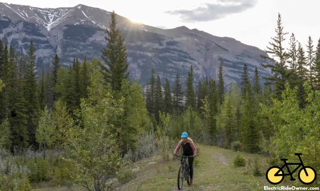 woman riding ebike on trail in mountainside