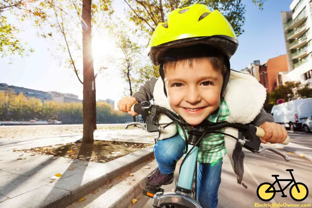 a smiling boy riding a bike