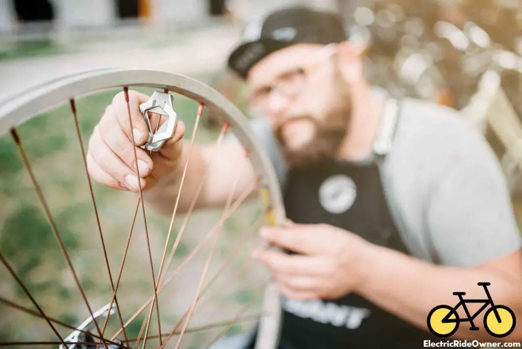 mechanic adjusts bike spoke